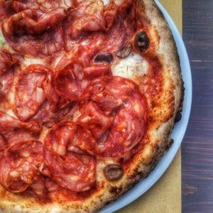 Pizza con mozzarella, salame piccante, olive