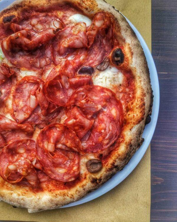 Pizza con mozzarella, salame piccante, olive